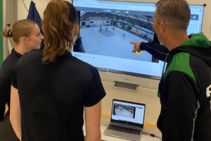 Trainer en spelers bekijken beelden van live-replay